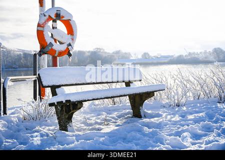 Panchina coperta di neve presso il molo dei traghetti Zollenspieker sull'Elba a Kirchwerder, Amburgo, Germania Foto Stock