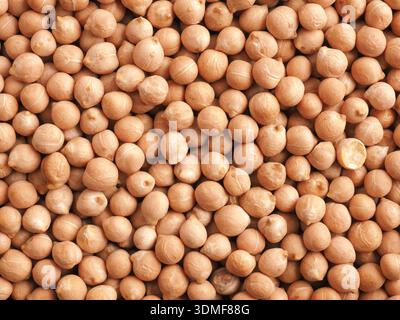 Ceci secchi biologici in una ciotola di legno su un tavolo da cucina rustico in legno, proteine vegetariane, cibo sano Foto Stock