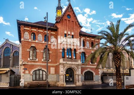 Lo storico edificio Concejalía de Comercio di Valencia, Spagna, presenta splendidi lavori in mattoni e piastrelle ornate accanto al famoso mercato centrale. Foto Stock