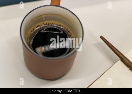 Comoda scrivania con tazza da caffè e notebook aperto Foto Stock