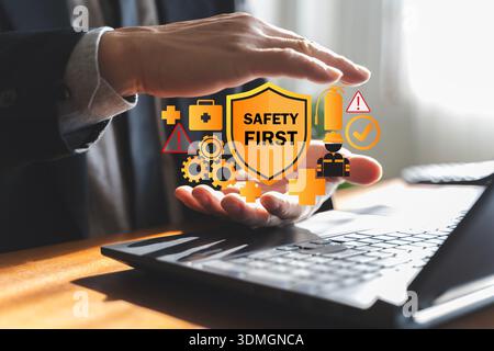 Le mani dell'uomo d'affari proteggono le icone del primo scudo sul laptop, concetto di gestione del rischio sul posto di lavoro, salute sul lavoro, conformità, emergenza p Foto Stock