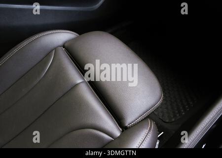Primo piano di un seggiolino per auto in pelle marrone premium con poggiapiedi, cuciture di alta qualità e design ergonomico per un comfort e un lusso Foto Stock