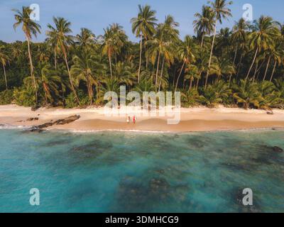 Scoprite la tranquilla bellezza della spiaggia di Takhian a Koh Kood, Thailandia, mentre le vibranti palme oscillano sopra le sabbie morbide e le limpide acque turchesi invitano al relax Foto Stock