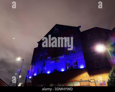 Manchester, Regno Unito - 21 gennaio 2026: Scena notturna di un mattone il Castlefield Hotel and Y Club a Liverpool Rd, Manchester è immerso in luci blu e in aree urbane Foto Stock