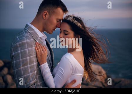 Coppia di nozze che cammina sulle rocce sul mare a Cipro Foto Stock