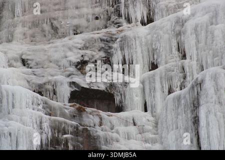 Tende di ghiaccio spesse e ghiaccioli su Frozen Cliff Foto Stock
