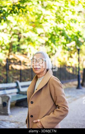 Donna asiatica anziana sicura di sé nel parco Foto Stock
