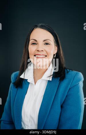 Donna professionista sorridente, che presenta fiducia e successo Foto Stock