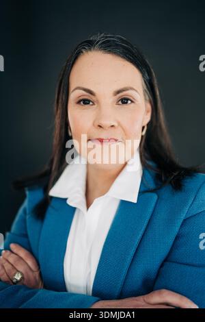 Donna professionista che posa braccia incrociate che guarda la telecamera Foto Stock