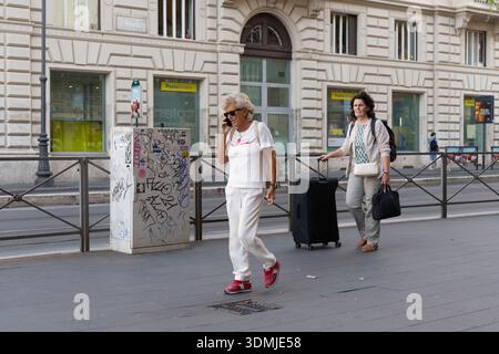 street due donne che camminano a roma cellulare bagagli con ruote Foto Stock