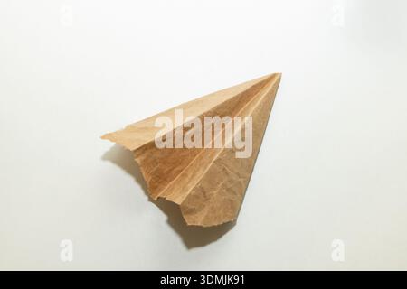 L'aereo fatto in casa era fatto di vecchia carta marrone strappata d'epoca su sfondo bianco Foto Stock