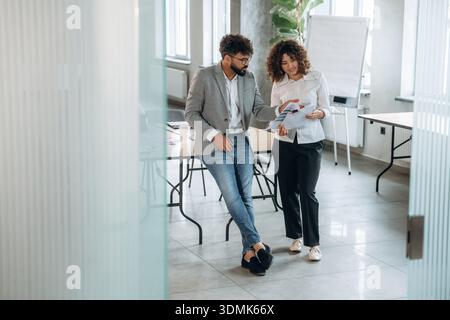 Documenti importanti sul progetto. Uomo e donna lavorano nell'ufficio moderno, nella concezione degli affari. Foto Stock