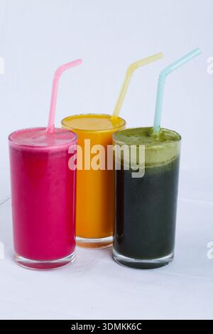 Colorati succhi di frutta e verdura freschi in vetro con cannucce isolate su sfondo bianco Foto Stock