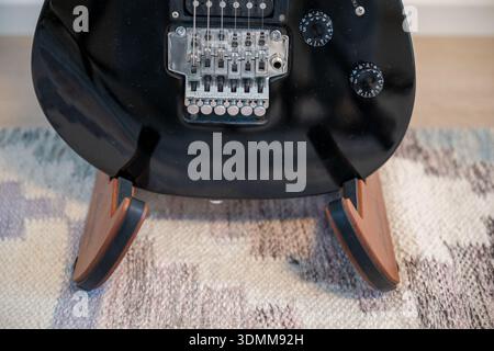 Dettaglio del corpo della chitarra elettrica con ponte in tremolo su piedistallo in legno Foto Stock