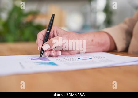 Firma dei documenti aziendali con penna su carta, lavoro d'ufficio, grafici e documenti professionali in ufficio Foto Stock