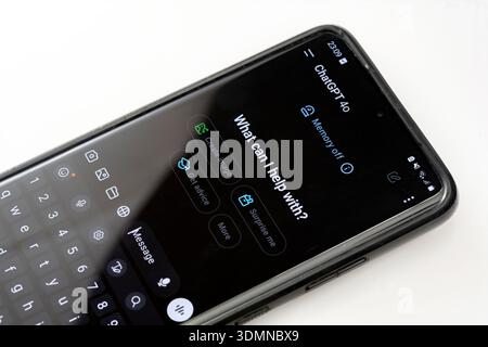 Smartphone con l'app OpenAI ChatGPT ai chatbot LLM aperta sullo schermo, interfaccia di conversazione con assistente per telefono cellulare in primo piano, artificia su sfondo bianco Foto Stock