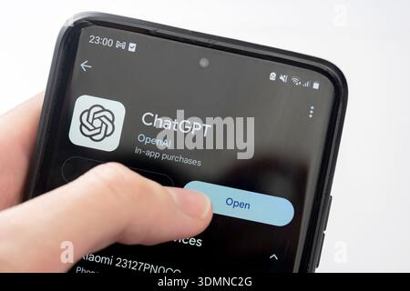 Pagina ufficiale dell'app OpenAI ChatGPT su Google Play Store, premendo a mano il pulsante di apertura. Software chatbot di intelligenza artificiale, smart mobile Foto Stock
