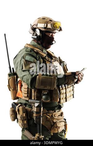 Personale tattico equipaggiato con equipaggiamento da combattimento avanzato che utilizza un dispositivo di comunicazione. Foto Stock