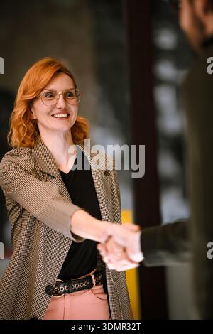 Incontro di lavoro tra due professionisti in un luminoso spazio ufficio con particolare attenzione al lavoro di squadra e alla collaborazione Foto Stock
