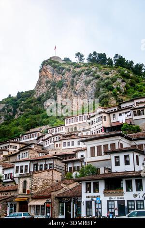 Case tradizionali albanesi, facciate della città vecchia di Berat con fortezza e castello di Berat sullo sfondo a Berat, Albania. Ideale per opuscoli di viaggio. Foto Stock