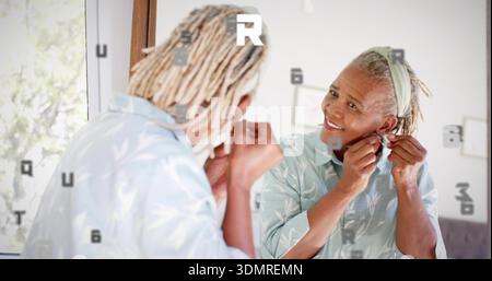 Allacciamento donna anziana orecchino regolabile a specchio in blusa stampata con archetto, spazio per copie Foto Stock