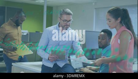 Rivedere l'uomo che indossa specifiche tenendo il tablet in ufficio mentre la donna asiatica in camicetta rosa consegna pagine Foto Stock