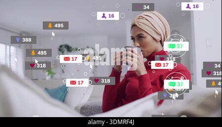 Tenere una donna in maglione rosso turban beige sorseggiando una tazza a casa con badge di notifica e spazio copia Foto Stock