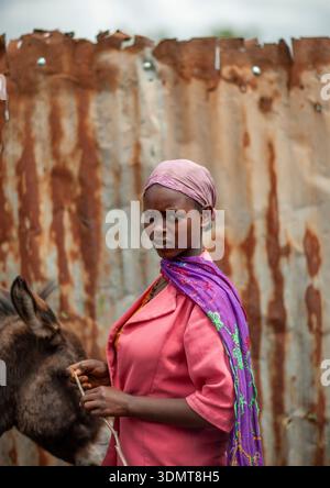 Ritratto di una donna di fronte a una recinzione arrugginita, Oromia, Woliso, Etiopia Foto Stock
