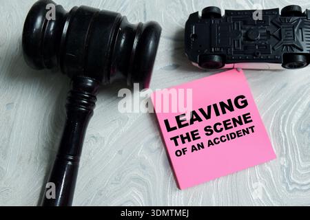 Concetto di lasciare la scena di un incidente scrivere su appunti adesivi isolati su un tavolo di legno. Rappresentando "hit an run", frode assicurativa, conseguenze legali Foto Stock