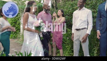 Sposa camminata in abito bianco in pizzo e velo con bouquet rosa pallido sul sentiero del giardino Foto Stock