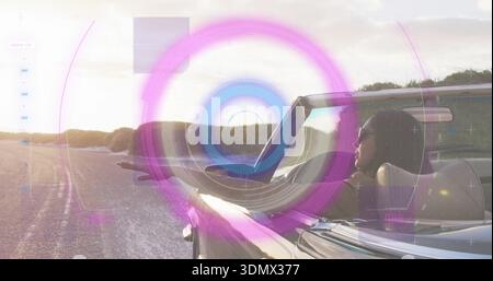 Indossa occhiali da sole donna indiana appoggiata sulla portiera dell'auto in argento convertibile su strada, HUD, spazio fotocopie Foto Stock