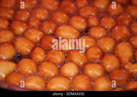 Le ciambelle o ciambelle sono fatte con una miscela di farina, zucchero, tuorli d'uovo, lievito e burro. Zucchero a polveri a forma di palla su una ciambella impilata Foto Stock