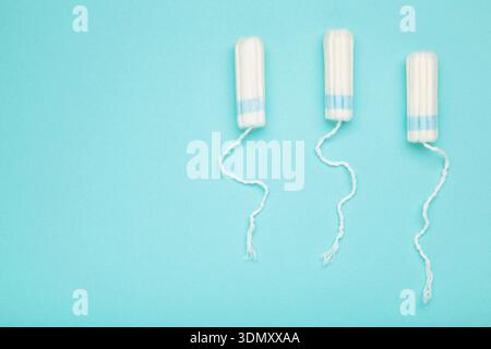 Tamponi di cotone per l'igiene delle donne periodo mestruale su sfondo blu. Spazio per il testo Foto Stock