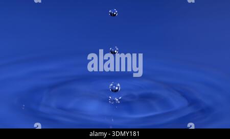 Goccioline d'acqua cadenti su sfondo blu, creando increspature in una superficie liquida calma Foto Stock