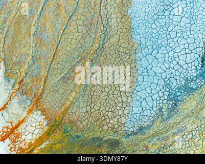 Un primo piano astratto della consistenza del suolo contaminato che rivela schemi superficiali intricati e incrinati. I contrasti di colore vivaci evidenziano la conc. Ambientale Foto Stock