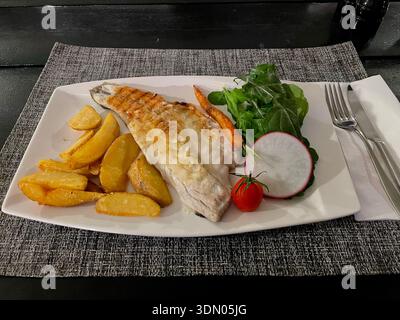 Filetto di pesce fritto con patate e verdure sul piatto , pronto da mangiare Foto Stock