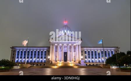 Vista notturna del Campidoglio dell'Oklahoma a Oklahoma City. Edificio neoclassico caratterizzato da cupola e colonne illuminate in un'atmosfera nebbiosa Foto Stock