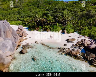 Fuggi verso la splendida spiaggia di Anse Cocos a la Digue, Seychelles, dove le acque cristalline si incontrano con le sabbie morbide. Rilassati sotto le palme ondeggianti mentre ti godi il brea Foto Stock