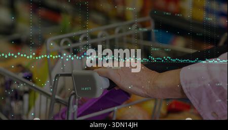 Afferrare una donna anziana con la parte superiore rosa che regge la maniglia del carrello nel corridoio del mercato con merci e sovrapposizione dati Foto Stock