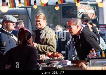 Man Evaluating wurst stand Offers presso l'International Grand Market in Hakaniemi Market Square nel quartiere Hakaniemi di Helsinki, Finlandia Foto Stock