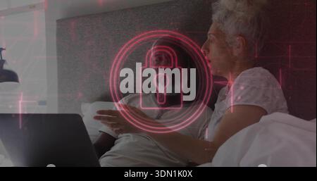 Coppia reclinabile che indossa una T-shirt leggera e una parte superiore con un laptop sul letto, lucchetto rosso sovrapposto Foto Stock