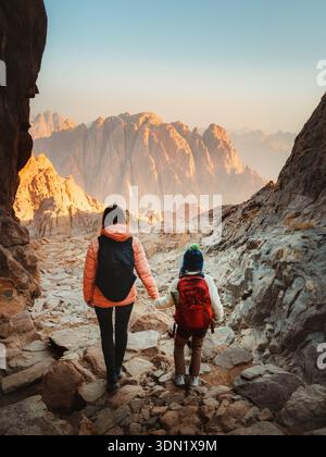Famiglia madre e bambino escursioni in Egitto viaggiano insieme godendo la vista delle montagne del Sinai, genitori e bambini giramondo in vacanza attiva sano li Foto Stock
