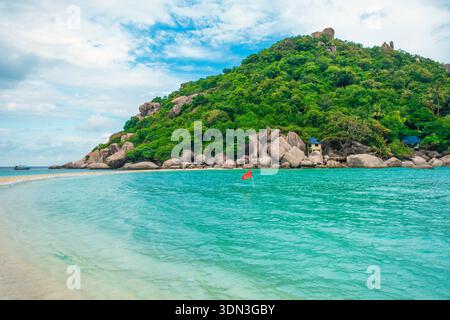 Spiaggia di sabbia bianca e acque turchesi all'isola tropicale di Nang Yuan, Koh Tao, con lussureggianti colline verdi e costa rocciosa, Thailandia. Destinazione di viaggio per Foto Stock