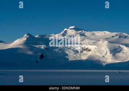 Veloce ghiaccio e montagne innevate nel fiordo di Bourgeois, nella baia di Marguerite, in Antartide. Foto Stock