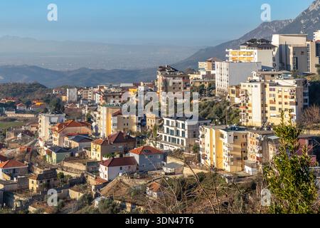 Vista panoramica di un quartiere residenziale collinare con edifici tradizionali e moderni con paesaggio montano balcanico, Kruja, Albania Foto Stock