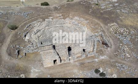 Vista aerea ad alto angolo del teatro romano di Acinipo e delle rovine circostanti nella campagna andalusa. Foto Stock