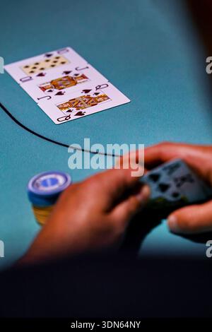 Primo piano di un uomo che gioca a poker Texas Hold 'Em e fa un salto con una scala reale, la mano più alta possibile Foto Stock