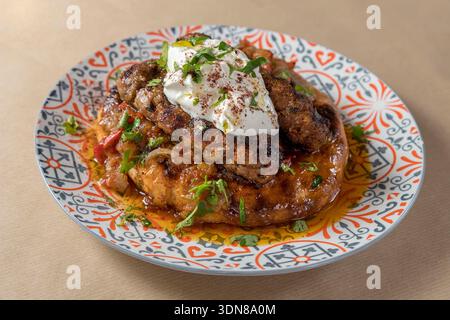 Autentico kebab yogurtlou greco con succosi spiedini di carne macinata alla griglia serviti su pane pita caldo, conditi con una ricca salsa di pomodoro speziata, un genere Foto Stock