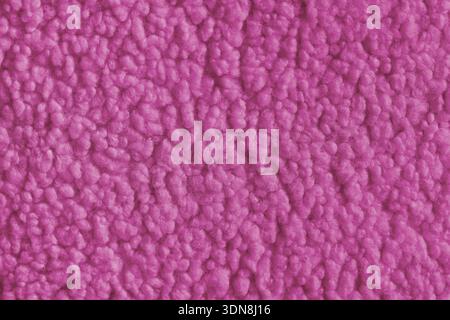 Tessuto di colore rosa brillante con morbida pelliccia sintetica con superficie morbida e sfondo astratto. Primo piano, texture di tessuto shaggy, tappezzeria Foto Stock