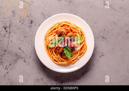 Spaghetti con polpette e salsa di pomodoro su sfondo di pietra, vista dall'alto Foto Stock
